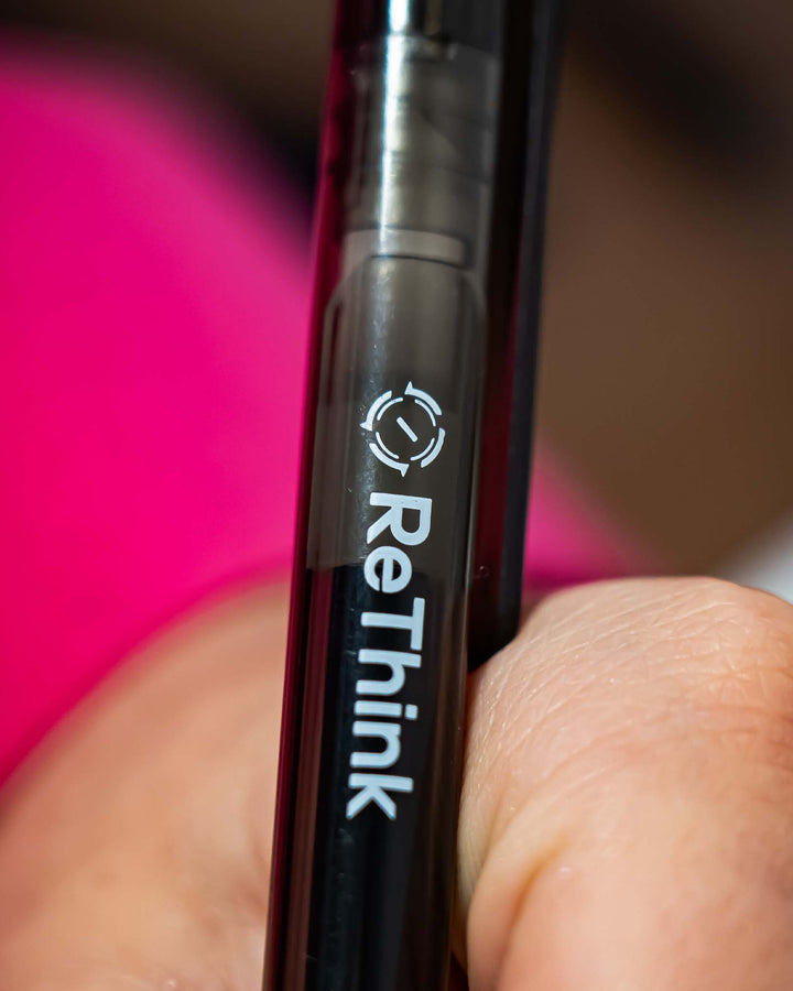 Gros plan sur un stylo noir ReThink tenu en main